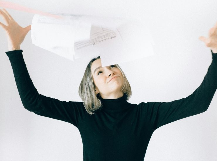 Ragazza felice lancia in aria le tasse da pagare