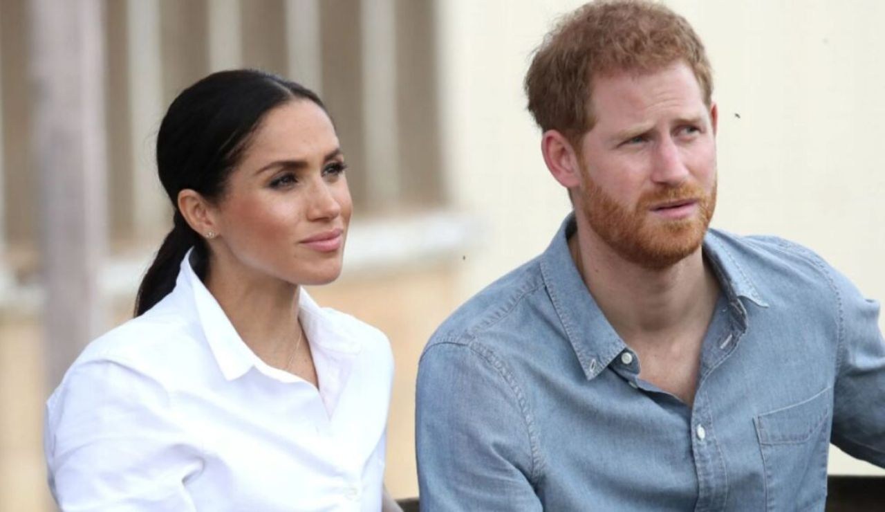 Meghan indossa una camicia bianca e Harry indossa una camicia azzurra scatto insieme