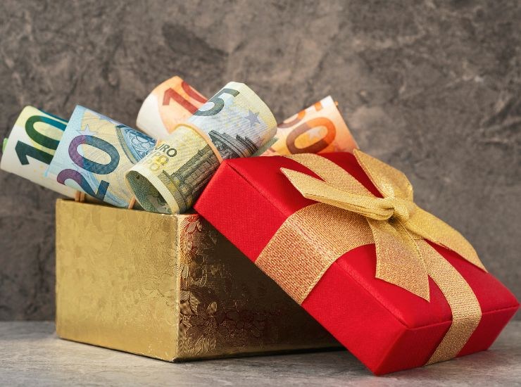 Primo piano di pacchetto regalo aperto con banconote in euro all'interno