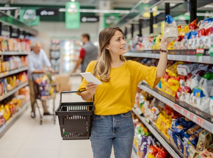 Donna che si aggira tra gli scaffali dei supermercati