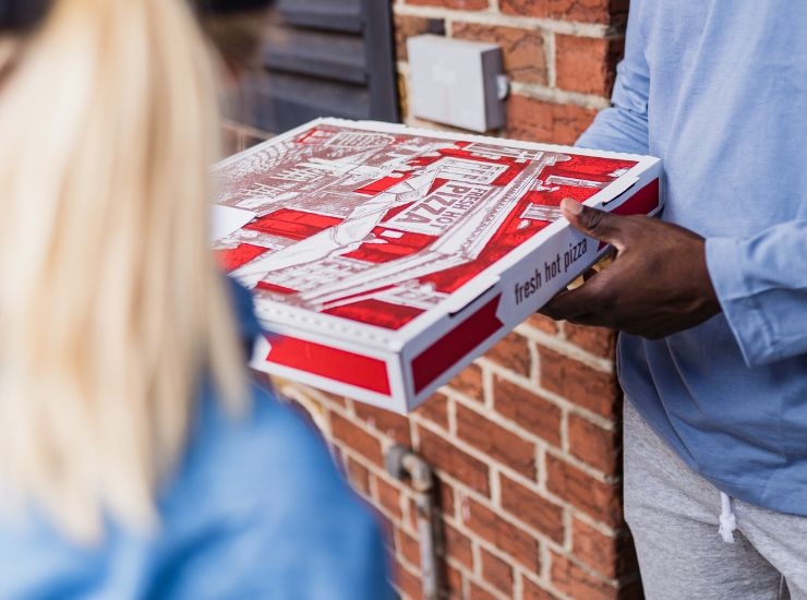 Consegna della pizza da asporto all'interno del cartone