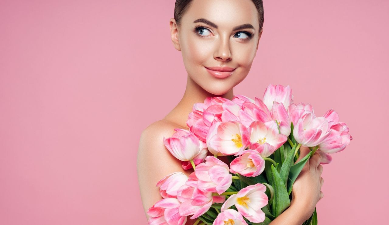 Ragazza con chignon e mazzo di fiori freschi 