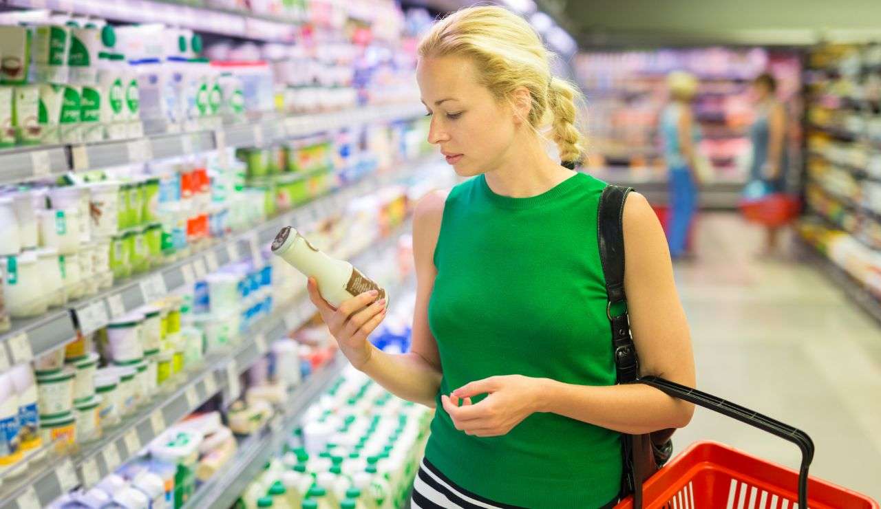 Ragazza legge l'etichetta di un prodotto alimentare al supermercato